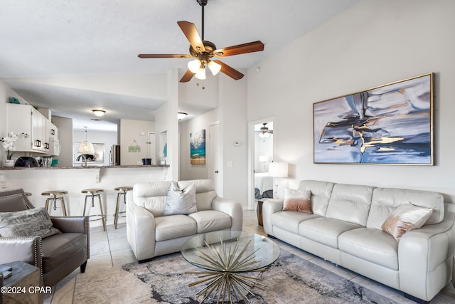 tiled living room featuring high vaulted ceiling and ceiling fan