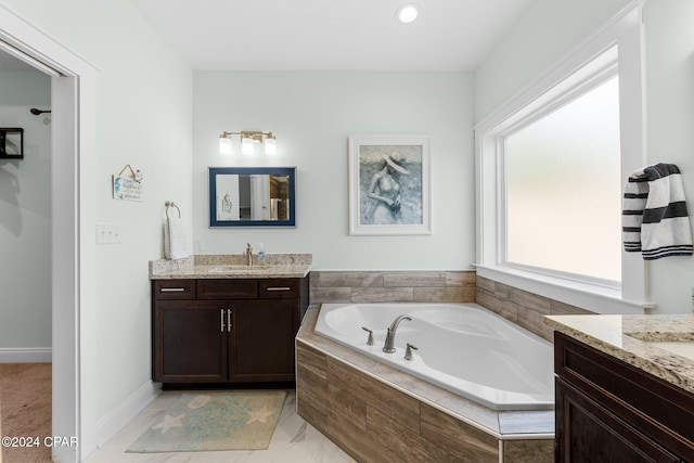 bathroom with vanity and tiled bath