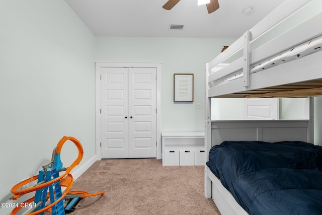 carpeted bedroom featuring ceiling fan and a closet