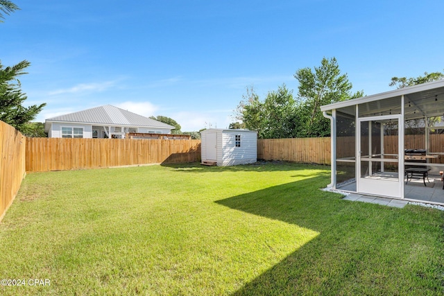 view of yard with a sunroom and a storage shed