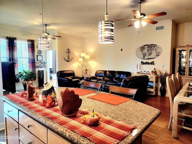 dining area with ceiling fan, dark wood-type flooring, and crown molding