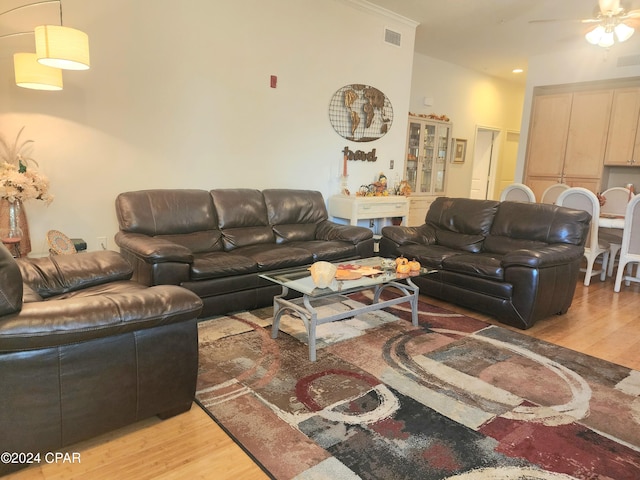 living room with ceiling fan, light hardwood / wood-style floors, and crown molding