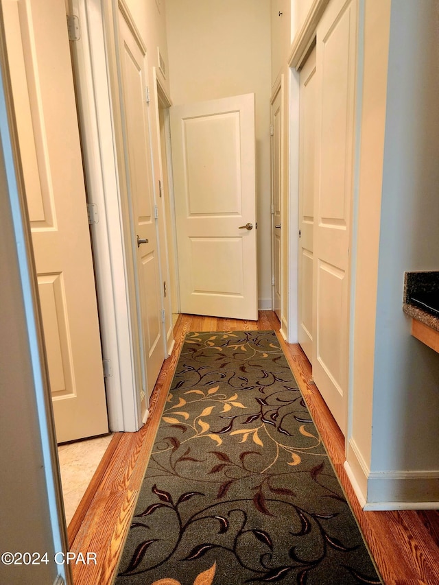 corridor with hardwood / wood-style floors