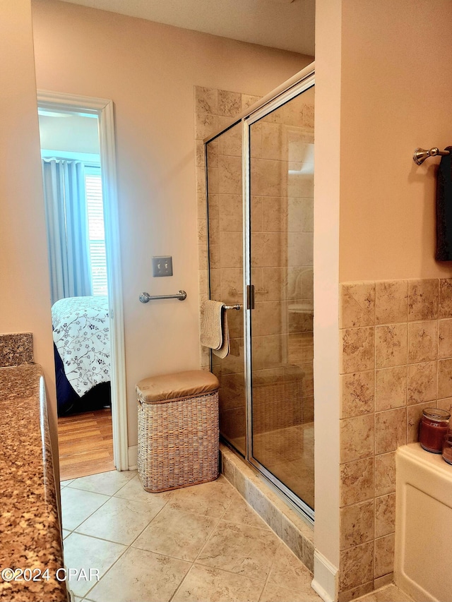 bathroom with tile patterned flooring and a shower with door