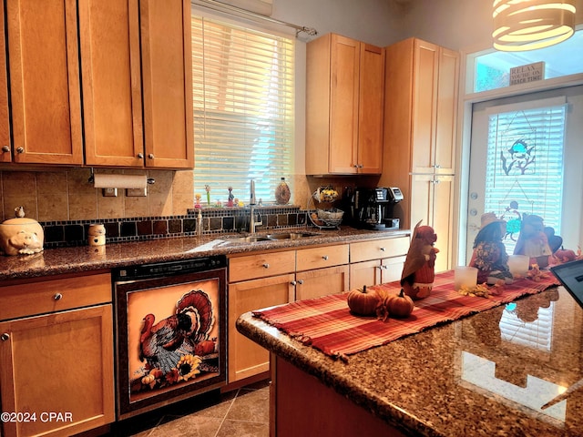 kitchen featuring sink, light tile patterned floors, a healthy amount of sunlight, and dark stone counters