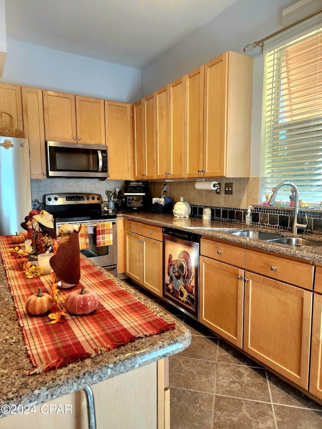 kitchen featuring stainless steel appliances, dark tile patterned flooring, light brown cabinets, sink, and tasteful backsplash