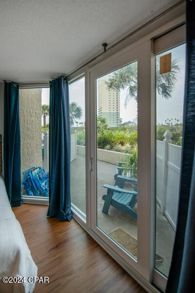 doorway to outside with hardwood / wood-style floors and a textured ceiling