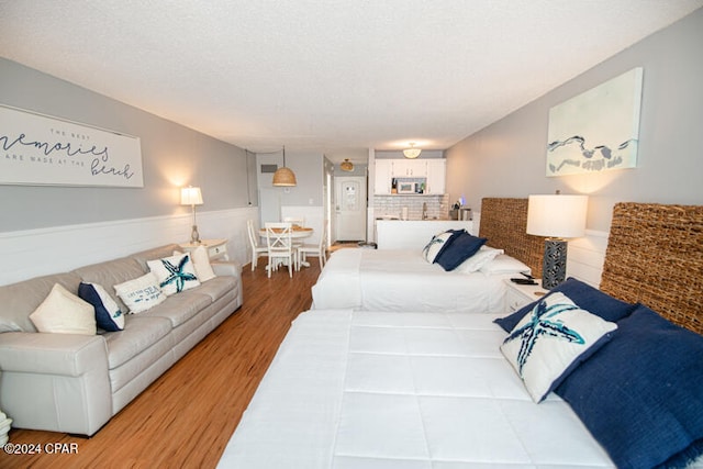 bedroom featuring hardwood / wood-style flooring and a textured ceiling