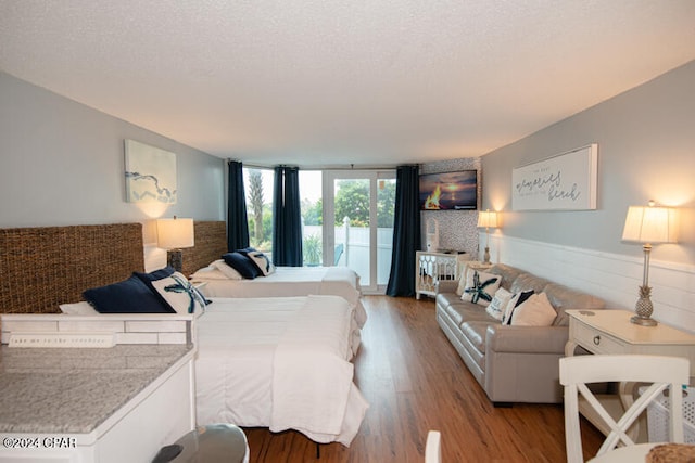 bedroom featuring a textured ceiling and light hardwood / wood-style flooring