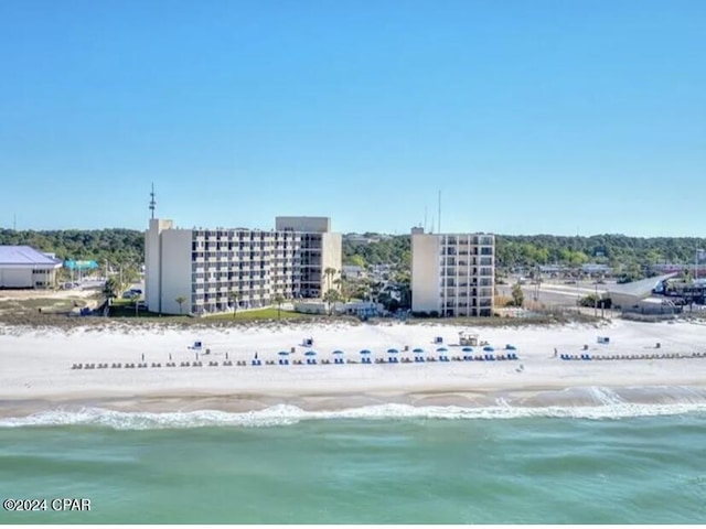 drone / aerial view featuring a beach view and a water view