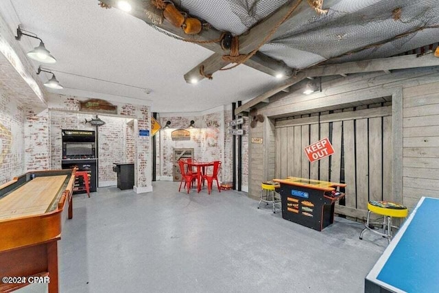 basement featuring wooden walls, brick wall, and a textured ceiling