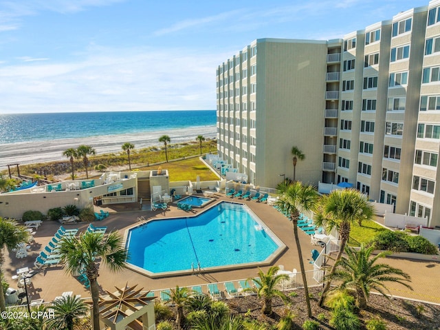 view of swimming pool featuring a view of the beach and a water view