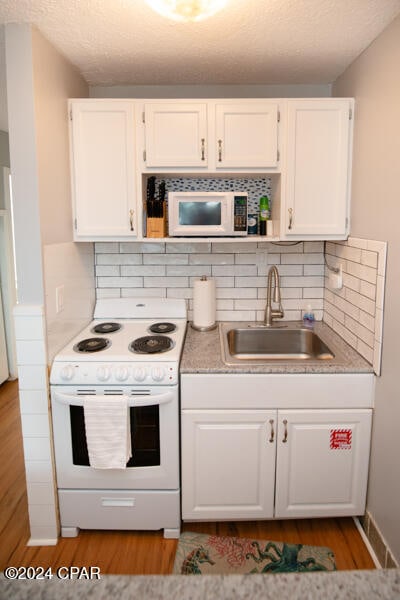 kitchen with white cabinets, white appliances, backsplash, and sink