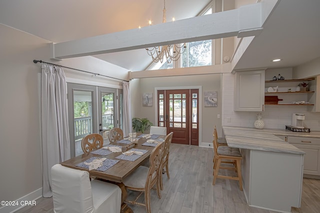 dining space featuring light wood-type flooring, lofted ceiling, and a notable chandelier