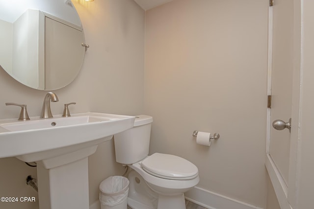 bathroom featuring baseboards, a sink, and toilet