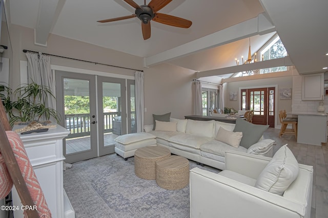 living room featuring vaulted ceiling with beams, light wood-type flooring, ceiling fan with notable chandelier, and french doors