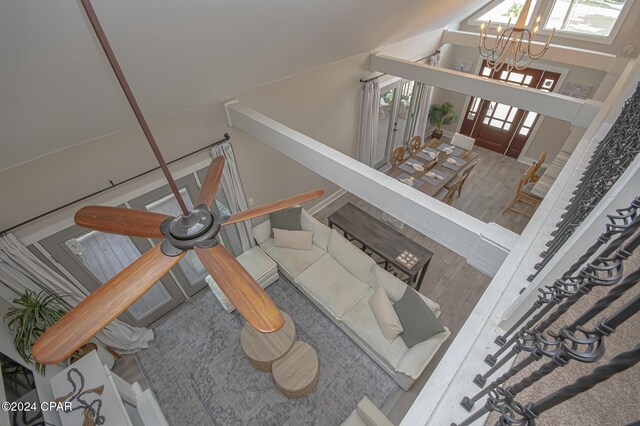 stairway featuring wood finished floors and an inviting chandelier