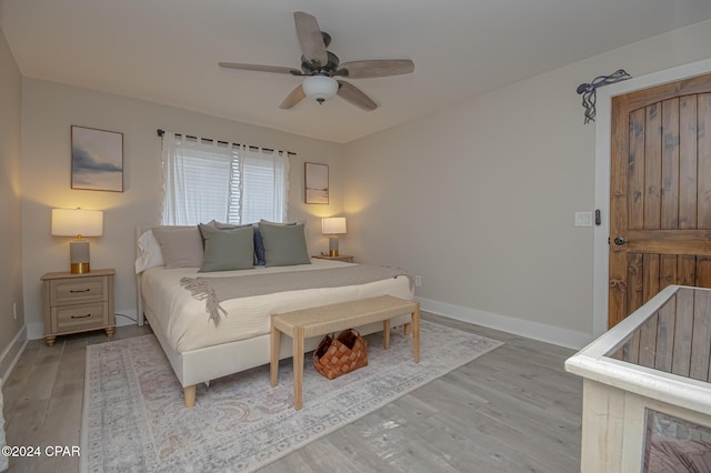 bedroom with light wood-style flooring, baseboards, and ceiling fan