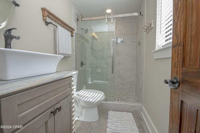 bathroom with marble finish floor, vanity, a marble finish shower, and toilet