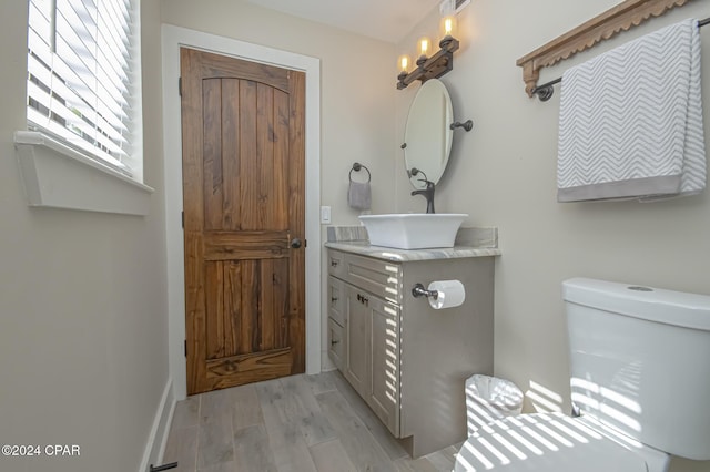 bathroom with toilet, wood finished floors, and vanity