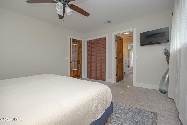 bedroom featuring a closet, visible vents, light carpet, ceiling fan, and baseboards