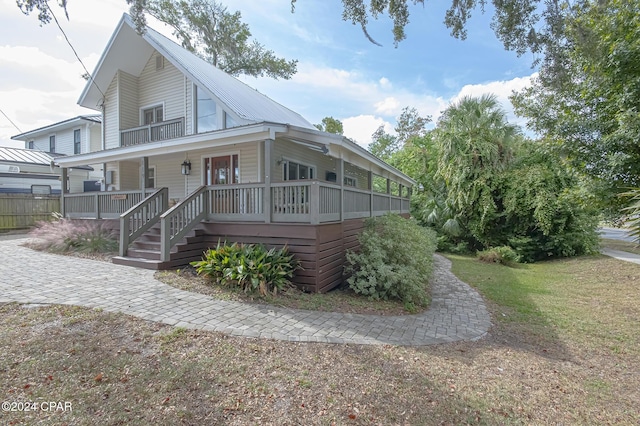 farmhouse with covered porch and metal roof