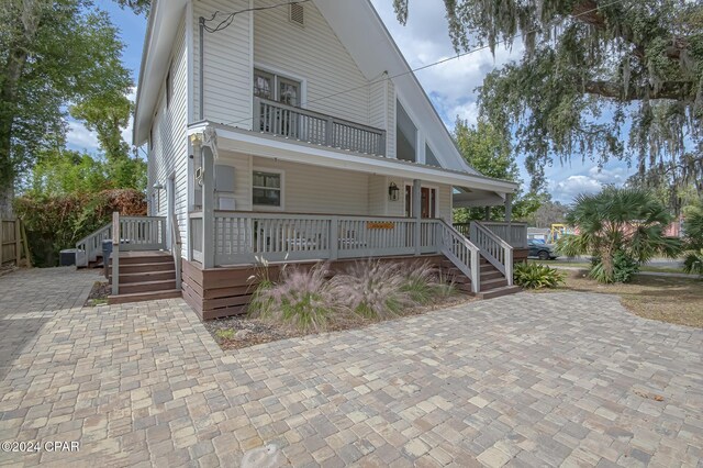 view of front of house with a porch and a balcony