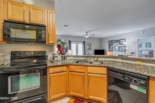 kitchen featuring sink, kitchen peninsula, stone countertops, light tile patterned floors, and black appliances