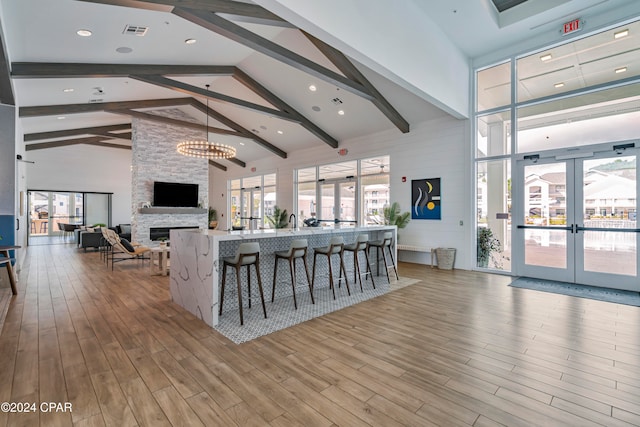 kitchen featuring high vaulted ceiling, light hardwood / wood-style flooring, a wealth of natural light, and french doors