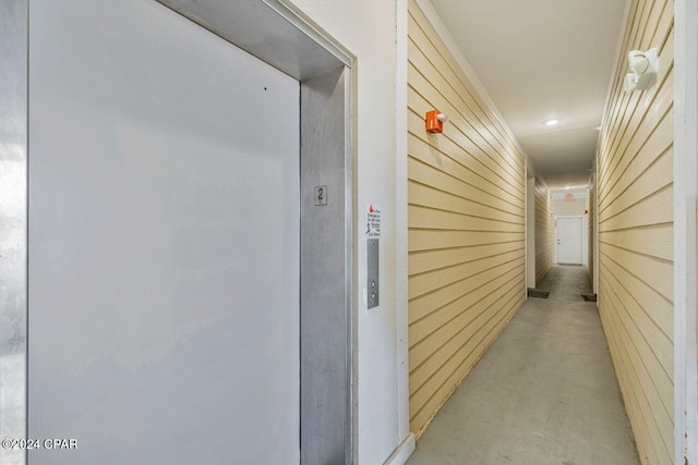 hallway featuring wood walls and elevator