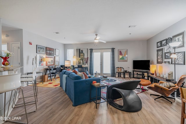 living room with french doors, light hardwood / wood-style floors, and ceiling fan