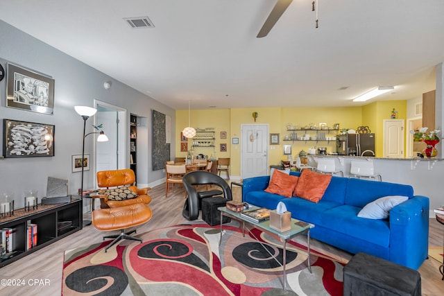 living room featuring ceiling fan and light hardwood / wood-style floors