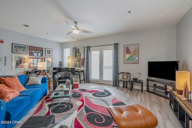 living room featuring ceiling fan, light hardwood / wood-style floors, and french doors