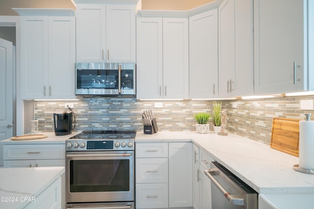 111 31st St Unit A & B, Mexico Beach, FL 32456 - kitchen with decorative backsplash, light stone countertops, white cabinets, and appliances with stainless steel finishes