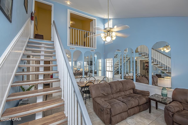 stairway featuring tile patterned flooring, ceiling fan, and a high ceiling