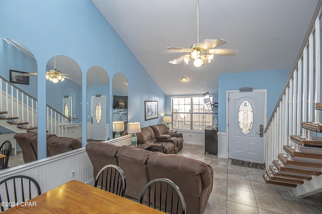 tiled living room featuring ceiling fan and high vaulted ceiling