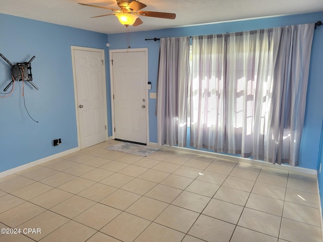 spare room featuring light tile patterned floors and ceiling fan