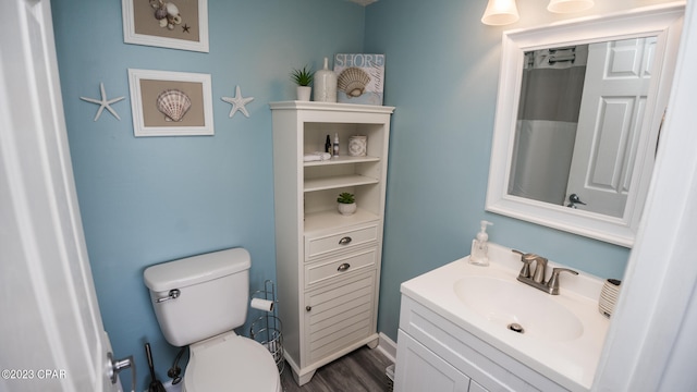 bathroom featuring wood-type flooring, vanity, and toilet