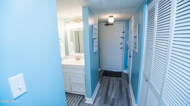 entryway with dark hardwood / wood-style flooring, a textured ceiling, and sink