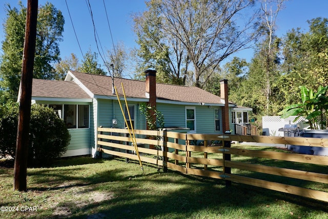 view of side of property featuring a lawn and a deck