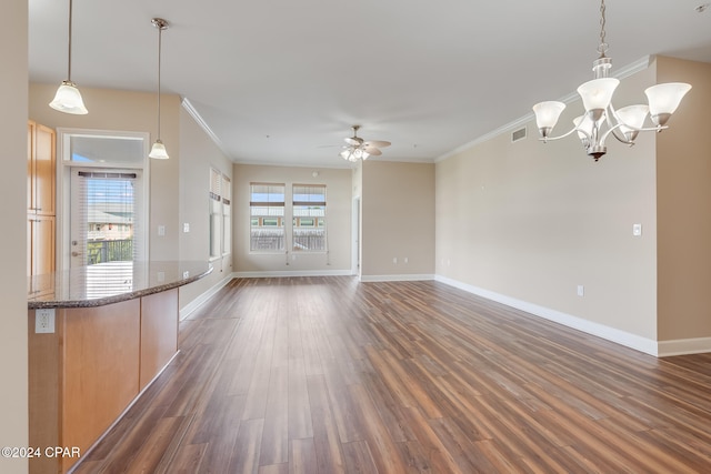 unfurnished living room featuring dark hardwood / wood-style floors, crown molding, plenty of natural light, and ceiling fan with notable chandelier