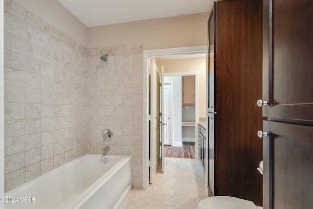 bathroom featuring wood-type flooring and tiled shower / bath