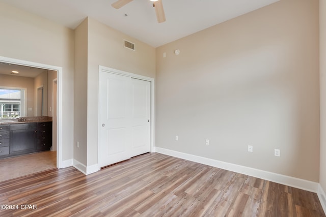 unfurnished bedroom with a closet, light hardwood / wood-style floors, and ceiling fan