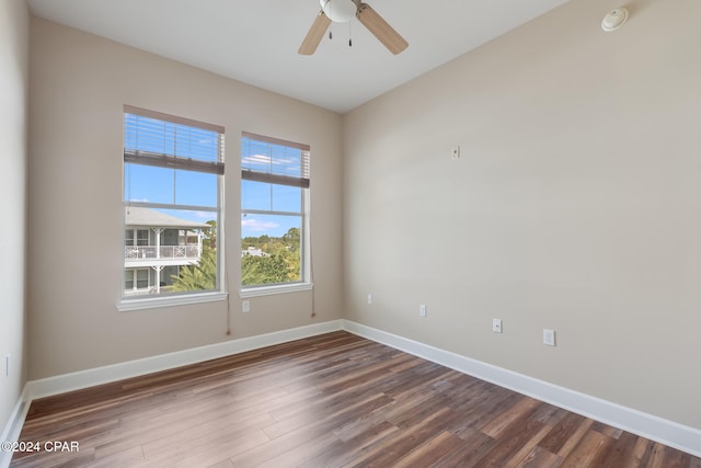 empty room with ceiling fan and dark wood-type flooring