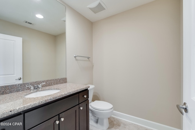 bathroom with tile patterned flooring, vanity, and toilet