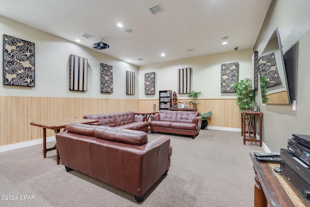 carpeted living room featuring wooden walls