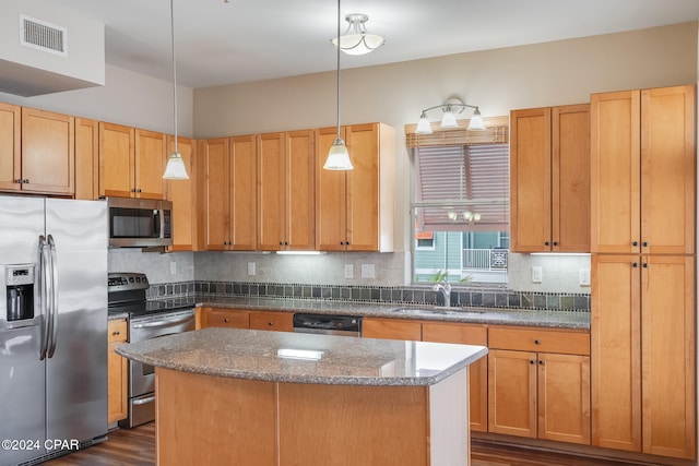 kitchen featuring stainless steel appliances, dark wood-type flooring, sink, pendant lighting, and a center island