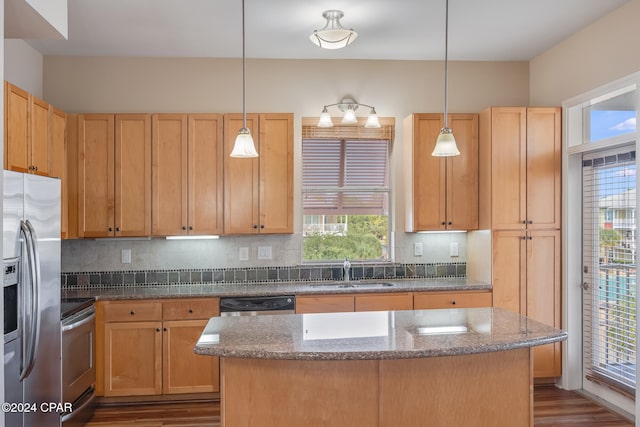 kitchen with sink, plenty of natural light, decorative light fixtures, and appliances with stainless steel finishes