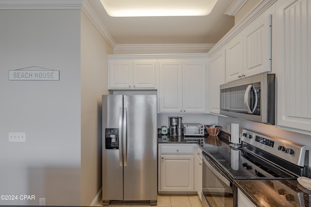 kitchen featuring white cabinets, dark stone countertops, ornamental molding, and appliances with stainless steel finishes