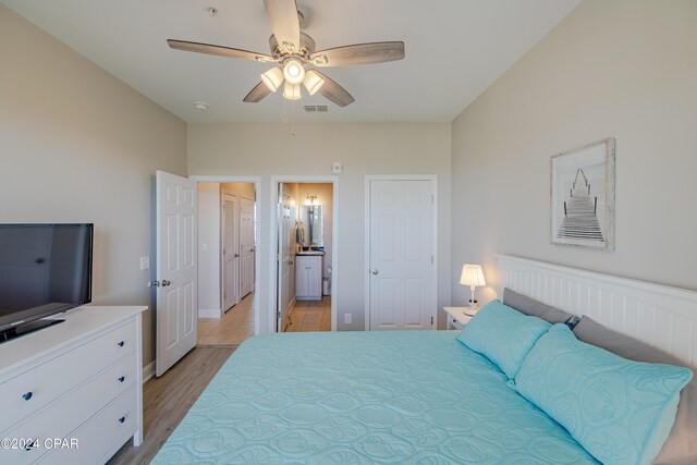 bedroom with light hardwood / wood-style flooring, ensuite bath, and ceiling fan